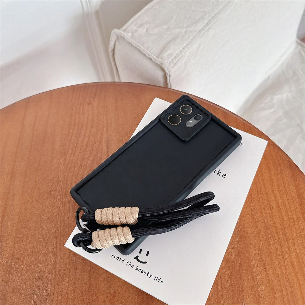Black phone case with a strap on a wooden table